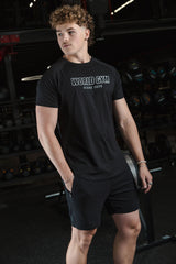 Person wearing a black 'World Gym' t-shirt in a gym setting