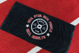 Black towel with gym-themed text and graphics on a red and white striped background