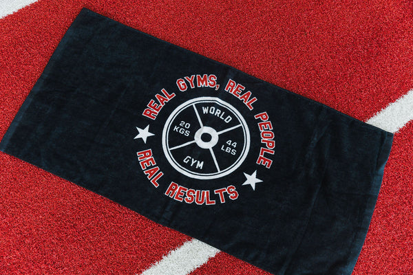 Black towel with gym-themed text and graphics on a red and white striped background